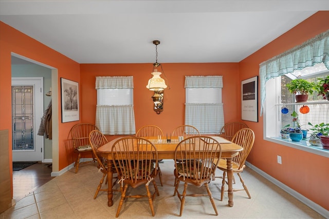 dining space with light tile patterned floors and baseboards