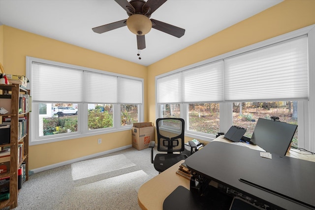 office area featuring light carpet, a healthy amount of sunlight, ceiling fan, and baseboards