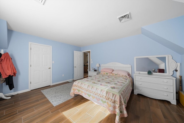 bedroom with wood finished floors, visible vents, and baseboards