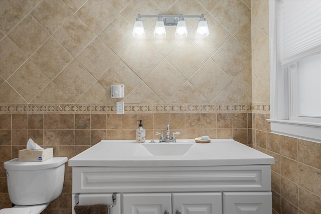 bathroom featuring toilet, tile walls, and vanity