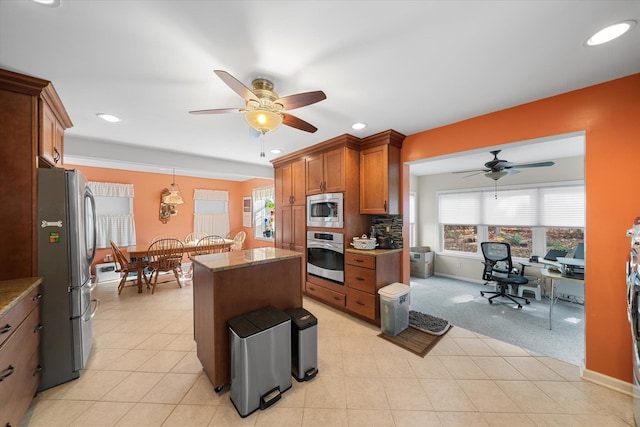 kitchen featuring light stone counters, recessed lighting, stainless steel appliances, a kitchen island, and brown cabinetry