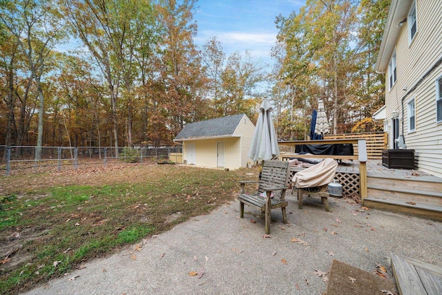 view of patio / terrace featuring fence, a deck, and an outdoor structure