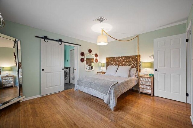 331 Holly Ln, Erma, NJ 08204 - bedroom with wood finished floors, visible vents, a barn door, and washer / dryer