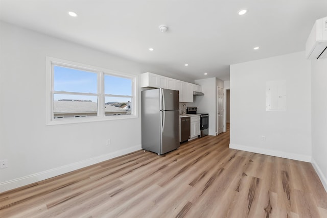 2001 Surf Ave Unit 11, North Wildwood, NJ 08260 - kitchen featuring appliances with stainless steel finishes, white cabinets, light wood-style flooring, recessed lighting, and an AC wall unit