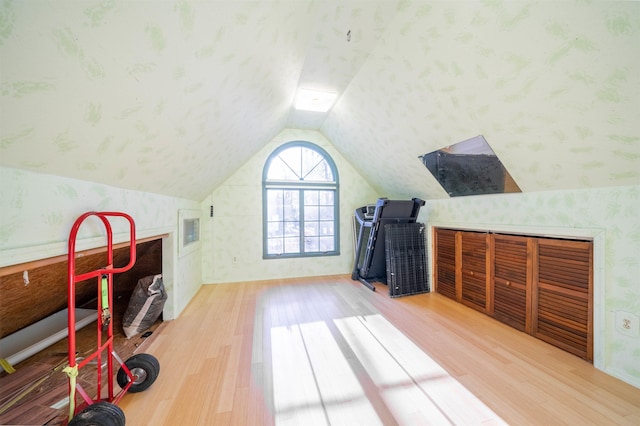 additional living space with hardwood / wood-style flooring and lofted ceiling