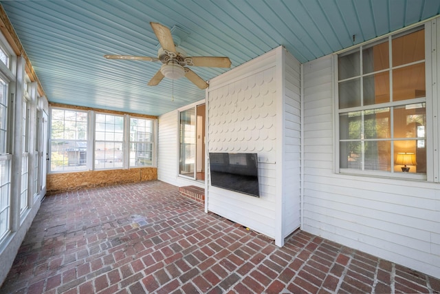 unfurnished sunroom featuring ceiling fan