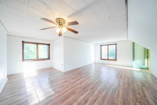 empty room with light wood-type flooring, vaulted ceiling, and ceiling fan