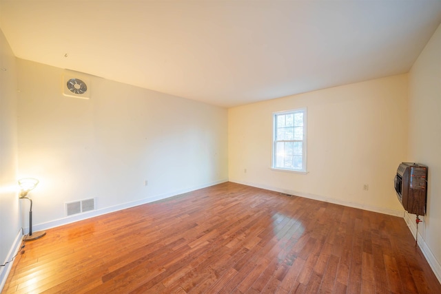 spare room featuring wood-type flooring and heating unit