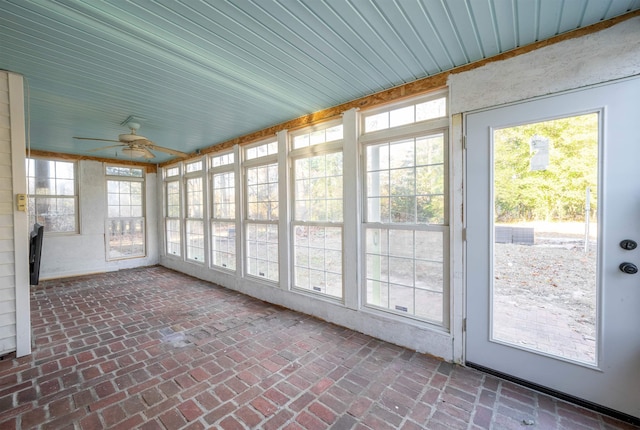 unfurnished sunroom featuring ceiling fan