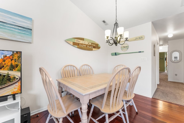 dining room with dark hardwood / wood-style flooring, a chandelier, and lofted ceiling