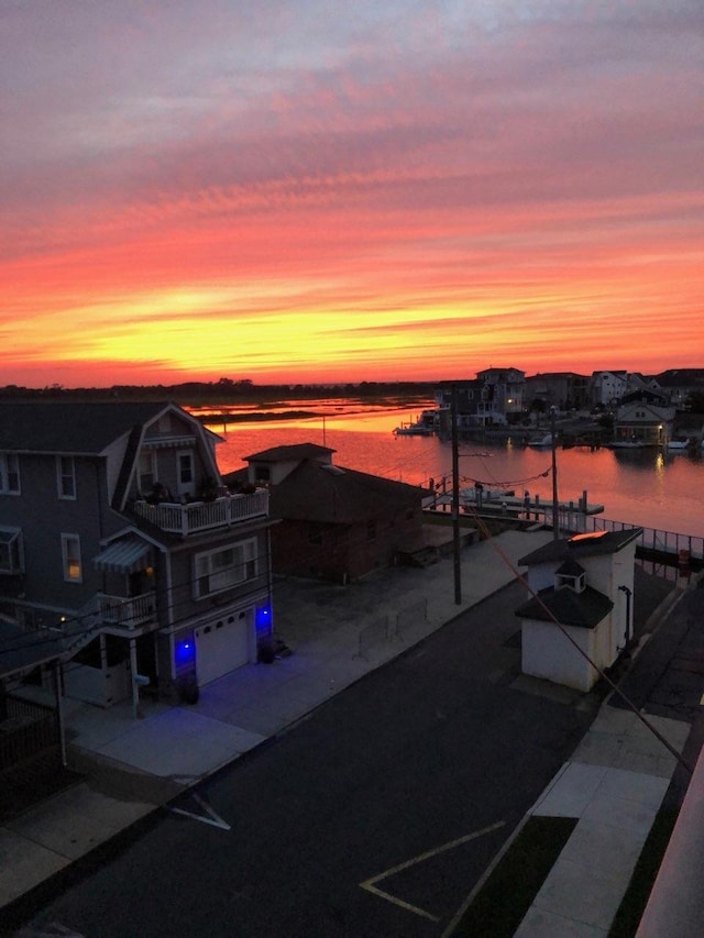 patio terrace at dusk with a water view and a garage