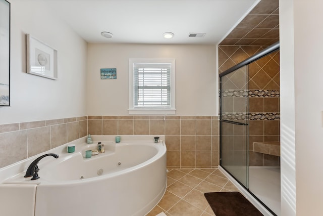 bathroom featuring tile patterned floors, tile walls, and plus walk in shower