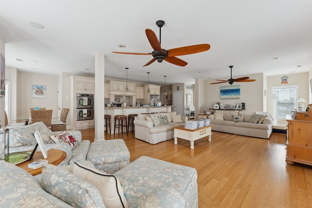 living room featuring light hardwood / wood-style flooring and ceiling fan