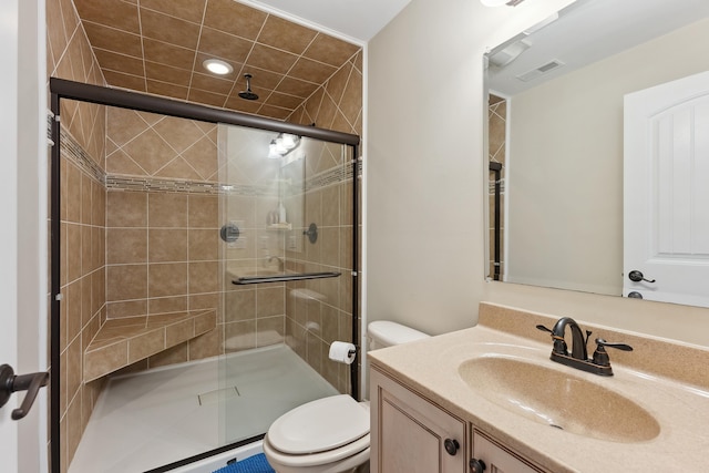 bathroom featuring vanity, toilet, and a shower with shower door