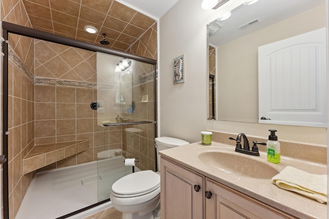 bathroom with tile patterned flooring, vanity, toilet, and a shower with door