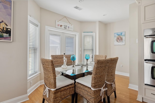 dining area featuring french doors and light hardwood / wood-style floors