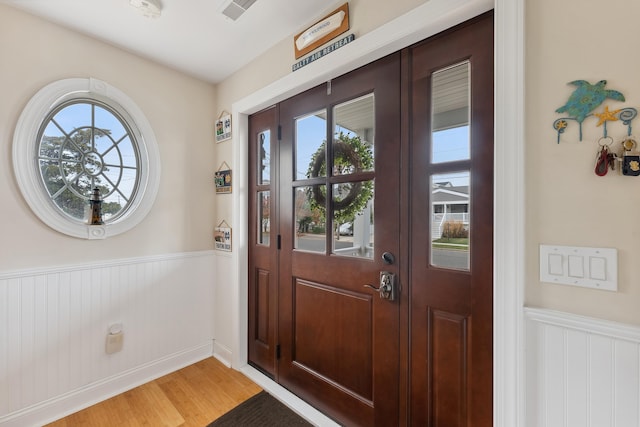 foyer entrance with hardwood / wood-style flooring and a healthy amount of sunlight