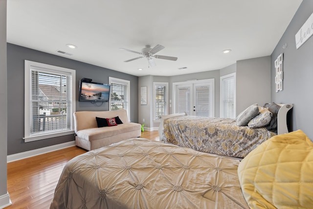 bedroom with ceiling fan, light hardwood / wood-style floors, and french doors