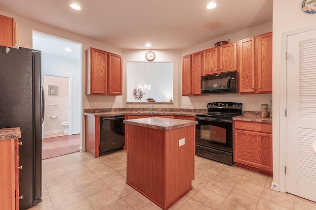 kitchen featuring sink, a kitchen island, and black appliances