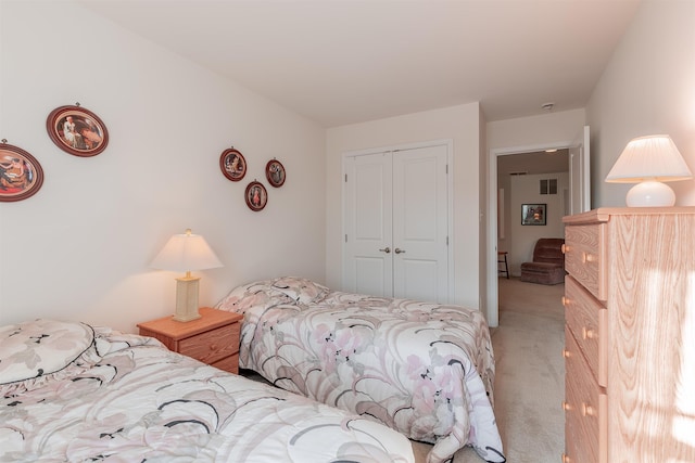 bedroom featuring a closet and light colored carpet