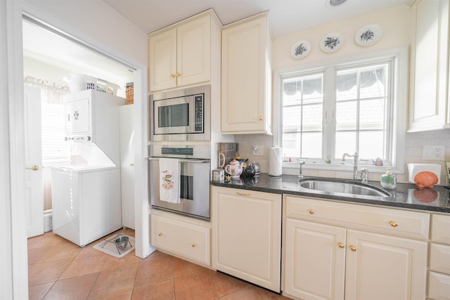 kitchen with backsplash, sink, light tile patterned floors, and stainless steel appliances