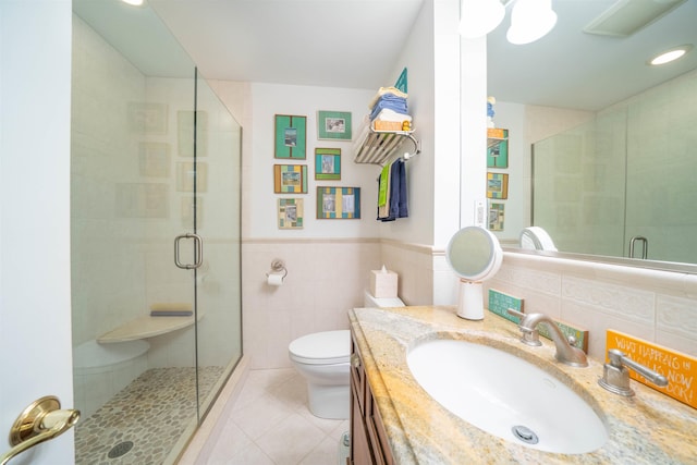 bathroom with vanity, tile patterned flooring, toilet, walk in shower, and tile walls