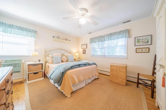 bedroom featuring baseboard heating, ceiling fan, light hardwood / wood-style flooring, and ornamental molding