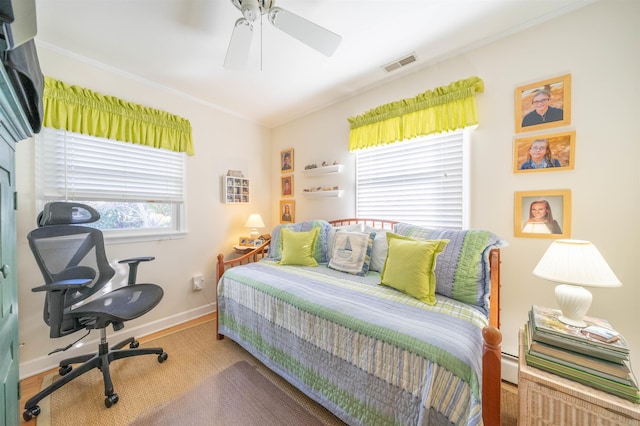 bedroom featuring ceiling fan and a baseboard heating unit