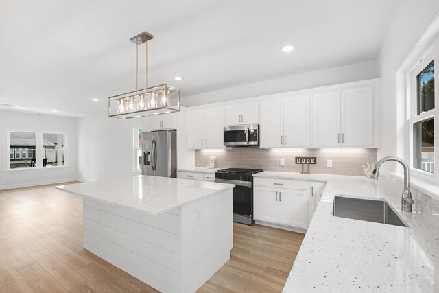 11 Oak Ave, Villas, NJ 08251 - kitchen featuring tasteful backsplash, light stone counters, appliances with stainless steel finishes, a kitchen island, and a sink