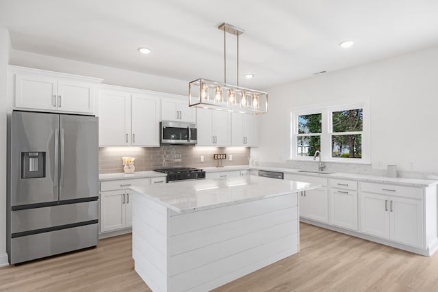 11 Oak Ave, Villas, NJ 08251 - kitchen with light wood finished floors, a sink, stainless steel appliances, tasteful backsplash, and white cabinetry