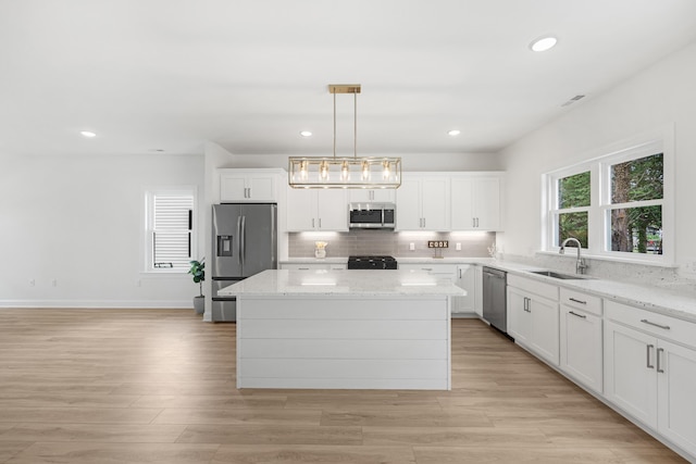 11 Oak Ave, Villas, NJ 08251 - kitchen featuring decorative backsplash, stainless steel appliances, a kitchen island, a sink, and light wood-type flooring
