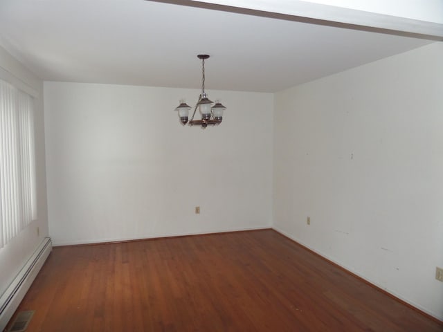 spare room featuring baseboard heating, an inviting chandelier, and wood finished floors