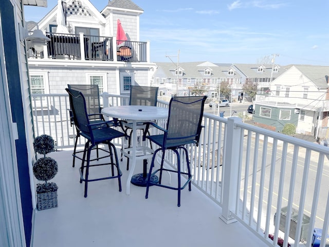 balcony featuring outdoor dining area and a residential view