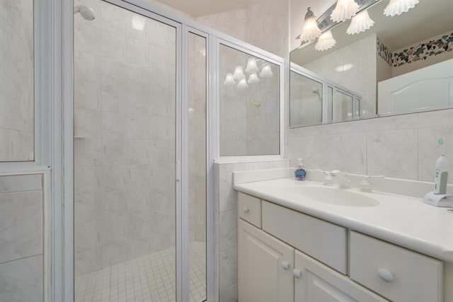 bathroom with vanity, an enclosed shower, and tile walls