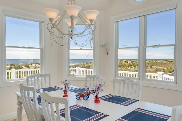 dining space with a water view and a notable chandelier