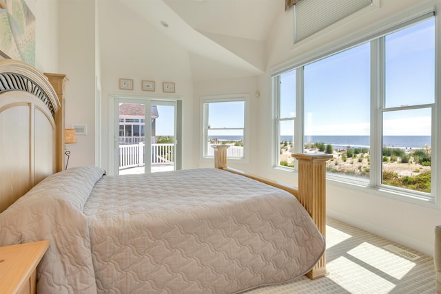 bedroom with access to outside, light carpet, a water view, and high vaulted ceiling