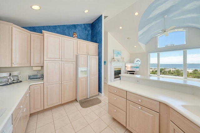 kitchen with ceiling fan, light tile patterned floors, and lofted ceiling