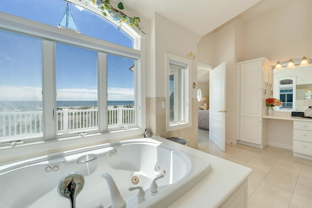 bathroom featuring tile patterned flooring and a relaxing tiled tub