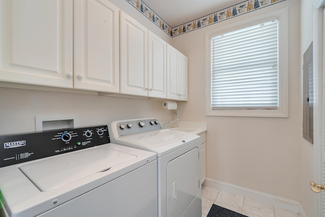 clothes washing area with washing machine and clothes dryer, light tile patterned floors, and cabinets