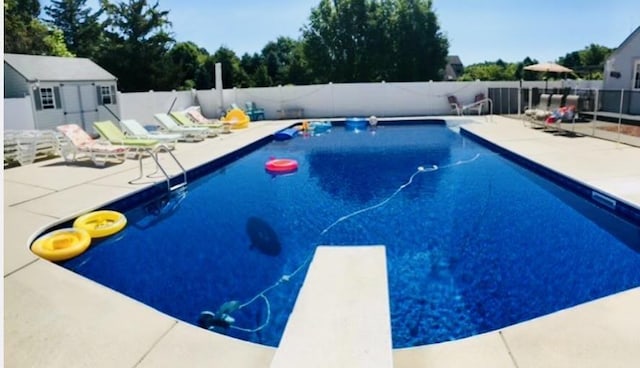 view of swimming pool featuring a patio area, a fenced backyard, a diving board, and a fenced in pool