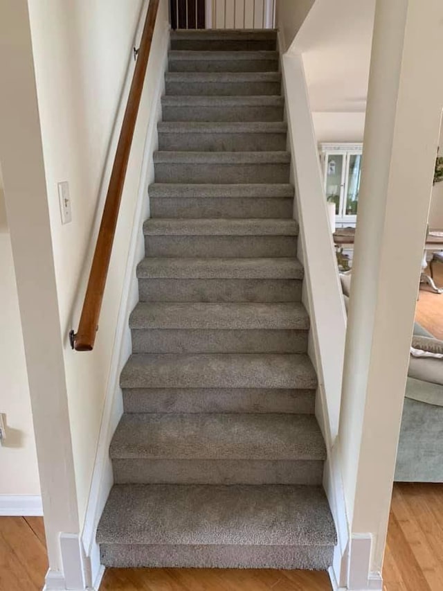 stairs with baseboards and wood finished floors