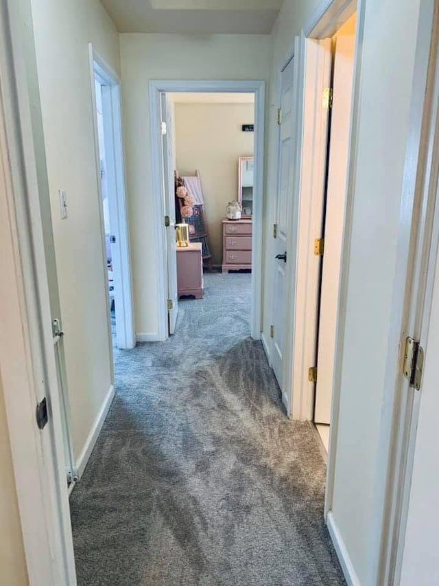 hallway with baseboards and carpet flooring