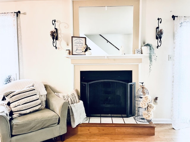 details with a fireplace with flush hearth, baseboards, and wood finished floors