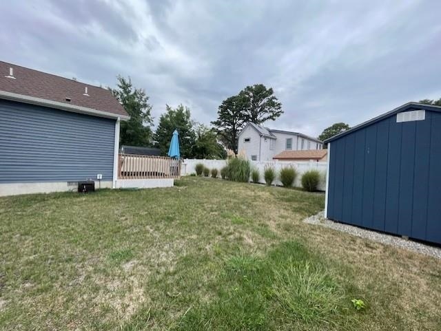 view of yard with a storage unit and a wooden deck