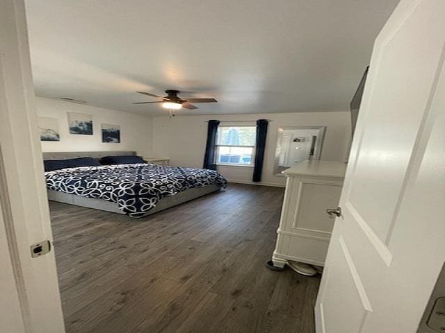 bedroom with dark hardwood / wood-style flooring and ceiling fan