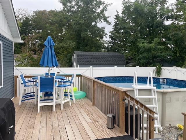 wooden deck featuring a fenced in pool