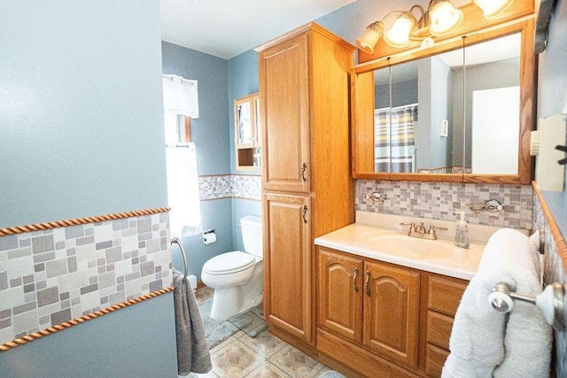 bathroom with toilet, vanity, and plenty of natural light