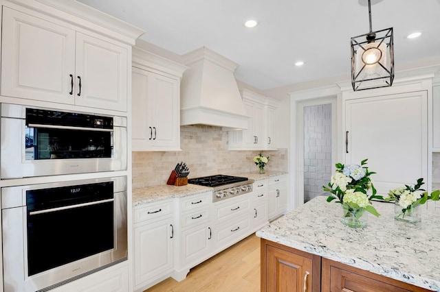 243 N Point Rd, Ocean City, NJ 08226 - kitchen with appliances with stainless steel finishes, custom range hood, white cabinets, light stone countertops, and backsplash