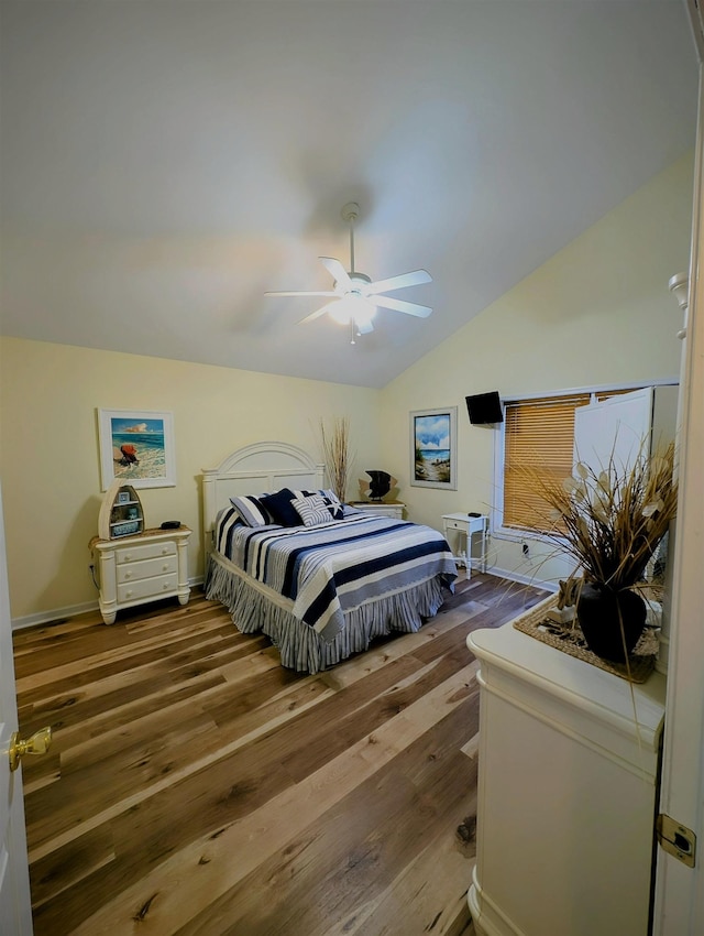 bedroom featuring hardwood / wood-style floors, vaulted ceiling, and ceiling fan