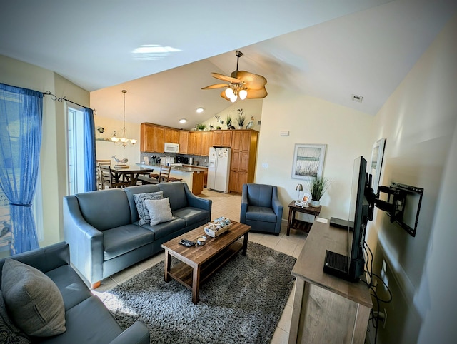 living room featuring ceiling fan with notable chandelier, lofted ceiling, and light tile patterned floors